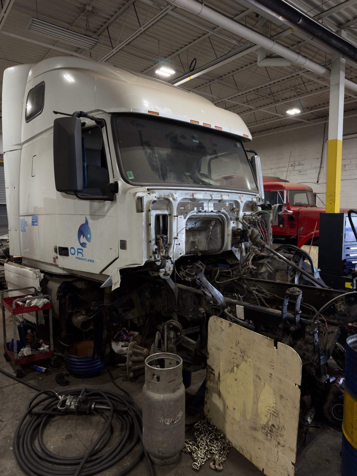 Heavy-duty truck with cab tilted exposing the engine and exhaust components for emissions service in Brampton