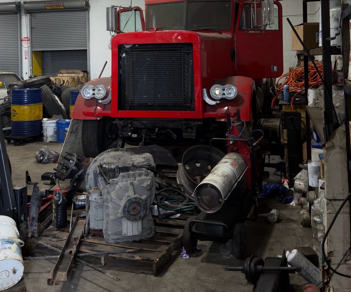 Heavy-duty truck up on stands with the transmission removed for service at the Planet Truck Brampton shop